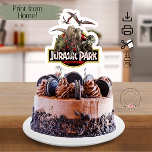 May include: A chocolate cake with Oreo cookie crumbs and chocolate frosting, topped with a printable Jurassic Park cake topper featuring a dinosaur and the words "Jurassic Park".
