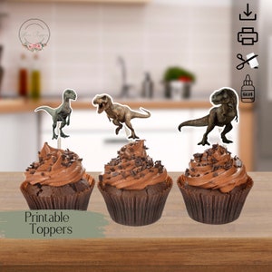May include: Printable dinosaur cupcake toppers featuring a green velociraptor, a brown Tyrannosaurus Rex, and a brown T-Rex with a green underbelly. The toppers are on top of chocolate cupcakes with chocolate sprinkles.