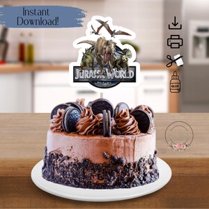 May include: A chocolate cake with Oreo cookie crumbs and frosting, topped with a Jurassic World cake topper featuring dinosaurs and the Jurassic World logo.
