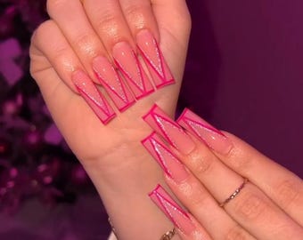 May include: Long, pink, square-shaped acrylic nails with a pink and white glitter finish. Each nail has a pink outline in the shape of a triangle.