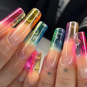 May include: Close-up of long, clear acrylic nails with a gradient of colors, including pink, orange, yellow, green, and blue. Each nail features a bubble design, creating a unique and artistic manicure.