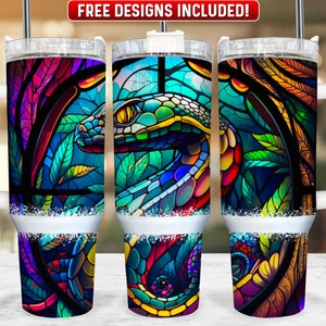Puede incluir: Tres vasos de acero inoxidable con un diseño de vitral colorido que presenta una serpiente. Los vasos tienen una tapa blanca y un asa blanca.