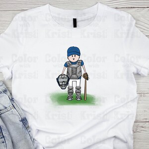 May include: White t-shirt with a cartoon illustration of a baseball catcher wearing a blue and white uniform, holding a catcher's mask and a bat.