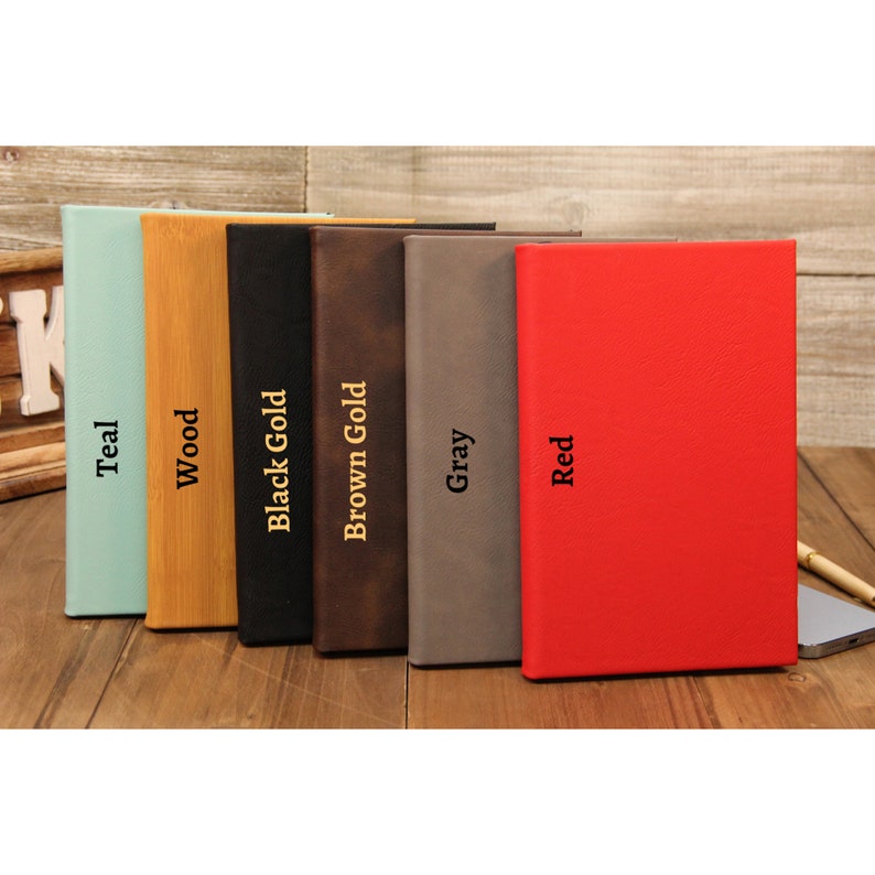 Puede incluir: Seis diarios de tapa dura en varios colores: turquesa, madera, negro, marr&oacute;n, gris y rojo. Cada diario tiene un color diferente y el nombre del color est&aacute; impreso verticalmente en el lomo con letras doradas. Los diarios est&aacute;n sobre una superficie de madera.