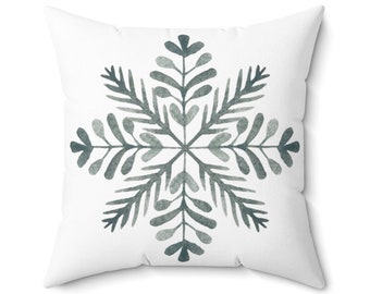 Puede incluir: Cojín cuadrado blanco con un diseño de copo de nieve en acuarela en tonos grises y verde azulado. El copo de nieve tiene un patrón botánico simétrico, ideal para la decoración de invierno o festiva. Un acento decorativo suave.