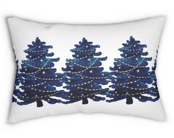 May include: A white rectangular pillow with a blue and white pattern of three Christmas trees with string lights.