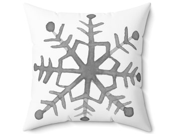 Puede incluir: Una almohada blanca con un diseño de copo de nieve gris acuarela.