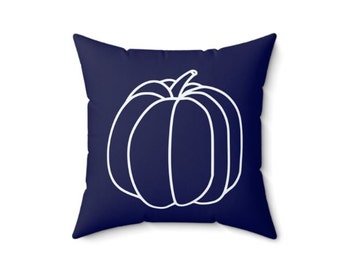 May include: A navy blue throw pillow with a white outline of a pumpkin.