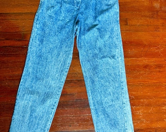 May include: Acid wash denim pants with a high waist and pleated front. The light blue jeans have a straight leg and cuffed hem. The pants are buttoned at the waist and have pockets.
