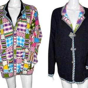 May include: Two jackets on a mannequin. The jacket on the left has a patchwork design with squares of pink, purple, blue, green, and yellow. The jacket on the right is black with a patterned trim and bow closures.