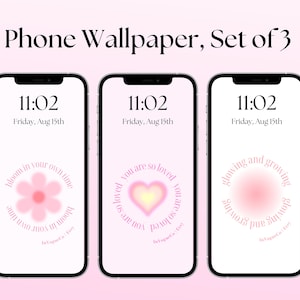 Op de afbeelding: Een set van drie telefoonachtergronden met roze en witte kleurschema's. De eerste achtergrond heeft een roze bloem met de tekst "bloom in your own time". De tweede achtergrond heeft een roze hart met de tekst "you are so loved". De derde achtergrond heeft een roze cirkel met de tekst "glowing and growing".