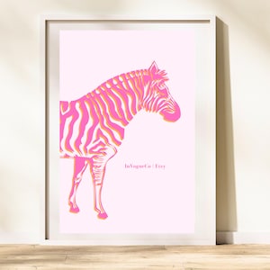 May include: A framed art print featuring a stylized zebra illustration. The zebra is depicted in vibrant pink and orange hues against a soft pink background. The print includes the text "InVogueCo | Etsy".