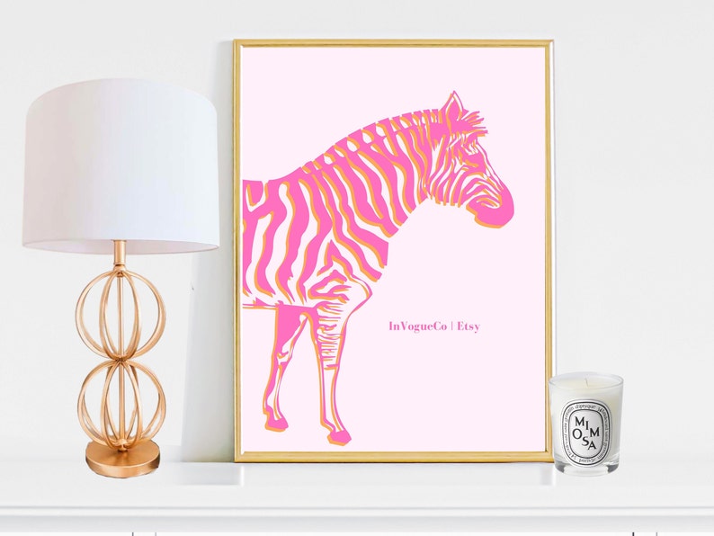 May include: A framed pink art print featuring a stylized zebra with pink and orange stripes. The artwork is set against a light pink background and framed in gold. The print includes the text "In Vogue Co | Etsy".