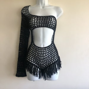 Peut inclure: Combinaison de bain noire en crochet avec une manche longue d'un c&ocirc;t&eacute; et une bordure en franges en bas.
