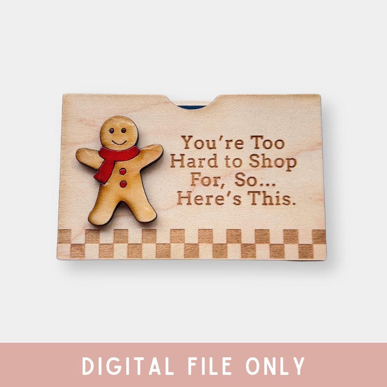 Pu&ograve; includere: Un biglietto di legno con un'illustrazione di un omino di pan di zenzero e il testo "You're Too Hard to Shop For, So... Here's This."