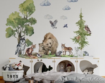 Może przedstawiać: Naklejki ścienne w akwareli z ilustracjami zwierząt leśnych, drzew i chmur. Scena obejmuje niedźwiedzia z młodymi, wilka, lisa, sowę i inne leśne stworzenia. Biała jednostka do przechowywania z zabawkami i szary dywan.
