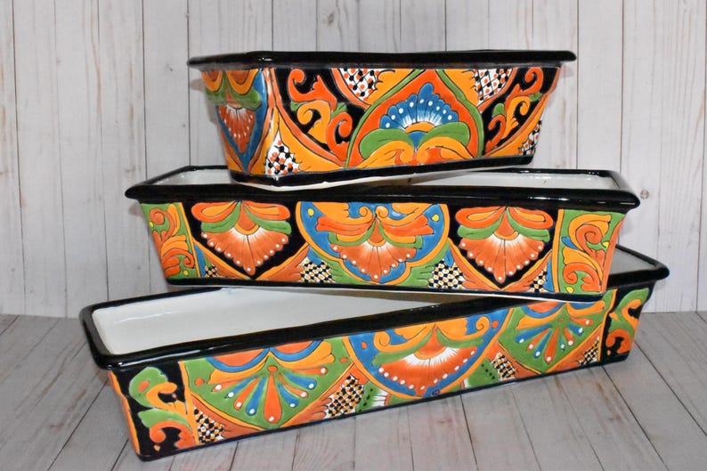 Pu&ograve; includere: Tre vasi da fiori in ceramica colorati con bordi neri e intricati motivi floreali in tonalit&agrave; di arancione, verde, blu e bianco.