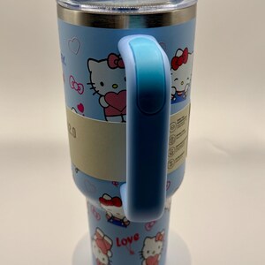 Pu&ograve; includere: Un bicchiere termico azzurro con un design di personaggi dei cartoni animati. Il bicchiere ha un manico e un coperchio blu abbinati. Il design include cuori e la parola "Love". Il bicchiere &egrave; progettato per contenere 2,0 litri.