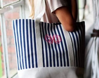 May include: A white and blue striped tote bag with a white bottom and a pink monogram that says "GJD".