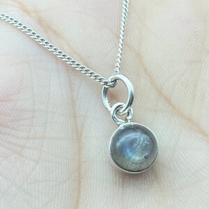 Może przedstawiać: Srebrny łańcuszek z okrągłym wisiorem z labradoritu.