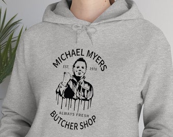 May include: A gray hoodie with a black graphic of Michael Myers from the Halloween franchise. The graphic says "Michael Myers" with "Est. 1978" above and "Always Fresh Butcher Shop" below.