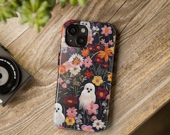 May include: A black phone case with a floral pattern and white ghosts. The flowers are pink, red, yellow, and orange. The case has a camera lens cutout.