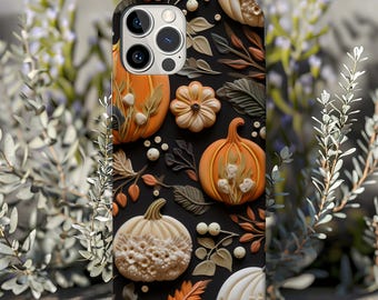 May include: A black phone case with a fall-themed design featuring pumpkins, leaves, and flowers. The case has a cutout for the camera lens and a gold trim around the edges.