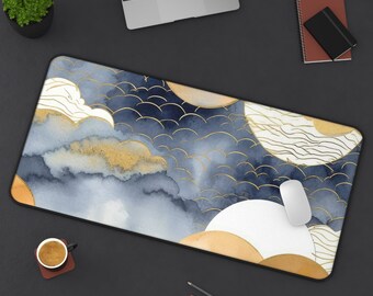 May include: A rectangular mouse pad with a watercolor design featuring blue, gold, and white cloud-like shapes. The pad has a black border and is placed on a dark surface with a laptop, coffee cup, and other office supplies.