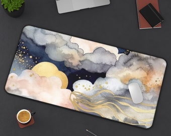 May include: A rectangular desk mat featuring a watercolor design of clouds, a golden moon, and gold accents. The color palette includes blues, grays, and pinks. A white mouse rests on the mat.