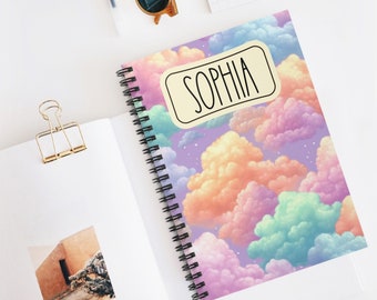 Könnte beinhalten: Ein spiralgebundenes Notizbuch mit einem farbenfrohen Wolkenmuster und dem Namen "Sophia" auf dem Einband.