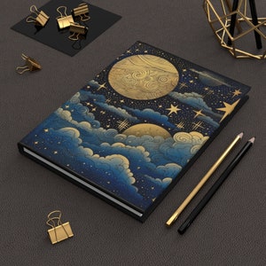 Peut inclure: Un carnet bleu foncé avec un motif en feuille d'or de nuages, d'étoiles et de lunes. La couverture présente une illustration détaillée d'un ciel nocturne avec des corps célestes.