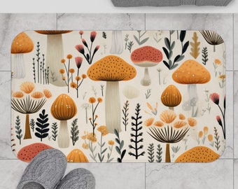 Könnte beinhalten: Eine beige Badematte mit einem sich wiederholenden Muster aus orangefarbenen, gelben und roten Pilzen mit grünen Blättern und Stielen. Die Pilze sind stilisiert und haben einen verspielten Charakter.