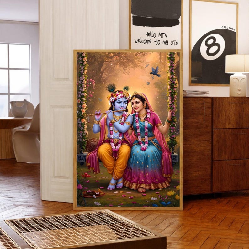 May include: A framed artwork shows a couple in traditional Indian dress, seated on a swing in a floral setting. The figures wear jewellery and hold a flute. The colour scheme includes blues, pinks, and yellows.