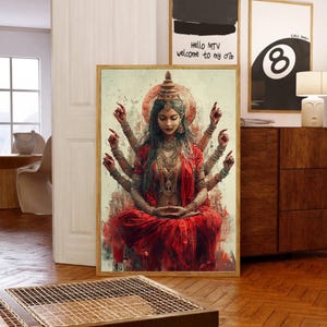 Puede incluir: Una impresión enmarcada que presenta una deidad de múltiples brazos con un sari rojo, adornada con joyas y una tiara. La obra de arte tiene una estética vintage con una paleta de colores cálidos. El fondo incluye otras obras de arte enmarcadas y muebles.