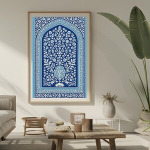 May include: A framed wall art print with a detailed blue and white floral design. The artwork has a central floral motif within an arched frame, set against a dark blue background. The print is in a light-coloured wooden frame.