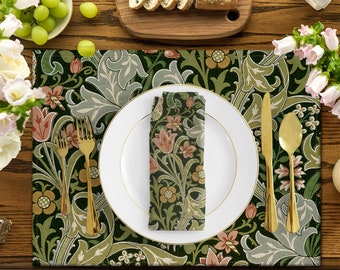 May include: A green and white floral patterned placemat with a white plate, gold cutlery, and a matching napkin. The placemat is set on a wooden table.