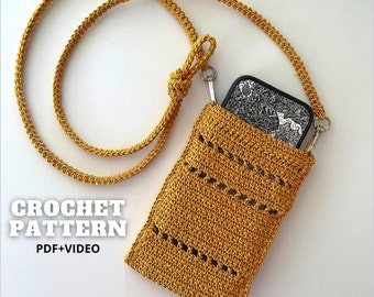 May include: A crocheted phone case with a mustard yellow color. The case has a strap that can be worn over the shoulder. The strap is also crocheted and is the same color as the case. The case has a pocket for a phone and a small opening for the phone's camera.