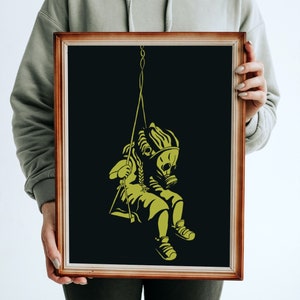 May include: Framed art print featuring a yellow illustration on a black background. The artwork depicts a figure wearing a gas mask and sitting on a swing. The frame is a warm brown color.