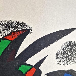 May include: Abstract art print featuring bold black brushstrokes and colorful geometric shapes in red, green, and yellow against a white background. The artwork has a textured, speckled appearance.