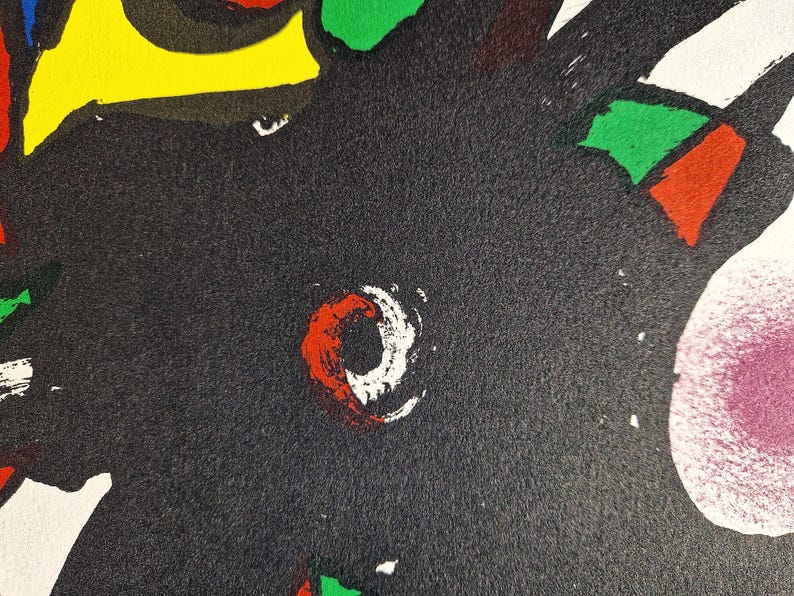 May include: Abstract artwork with a textured black background. The design features bold shapes in red, white, green, yellow, and blue. A prominent red and white circular shape is visible.