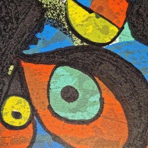 May include: Abstract artwork featuring bold shapes and colors. The composition includes a large eye with a green iris and black pupil, surrounded by orange and brown. Other shapes include yellow, blue, and black elements, creating a vibrant and dynamic design.