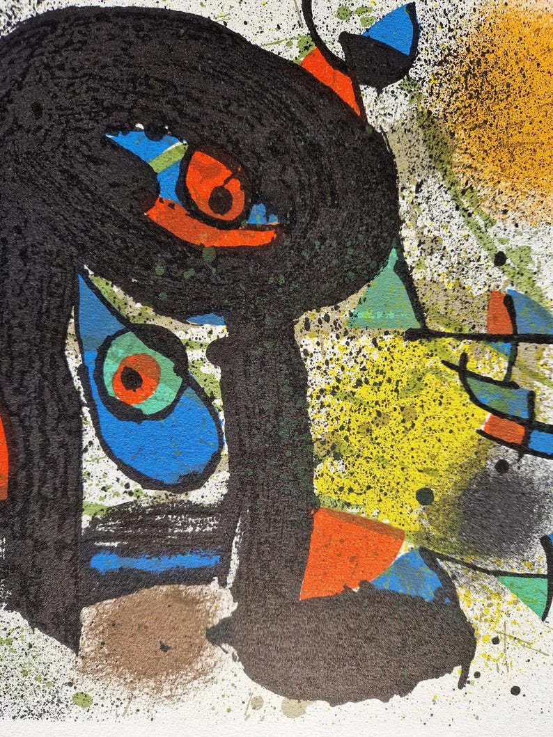 May include: Abstract artwork featuring a black, textured form with orange, blue, and green accents. Splatters of yellow and black paint add to the artistic composition. The artwork is on a white background.