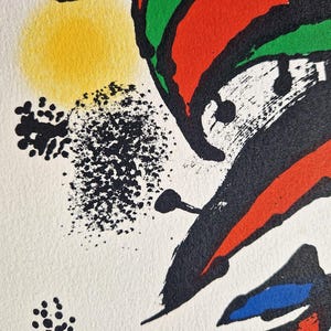 May include: Abstract art print with a white background and bold, colorful shapes. Features a yellow circle, black splatters, and red, green, and blue brushstrokes. The artwork has a textured appearance.