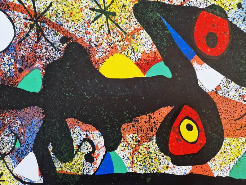 May include: Abstract art print with a black, white, red, yellow, and green color scheme. The print features a large black shape with a yellow sun and a red and yellow eye.