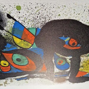 May include: Abstract art print featuring bold black shapes with orange, yellow, blue, and green accents. The artwork includes splatters and geometric forms, creating a dynamic composition. The print is on a white background.