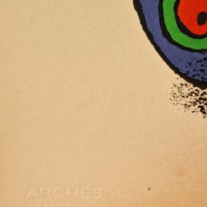 May include: Abstract art print featuring a blue, green, and red circular design with a black outline. The print is on a beige background, with the text "ARCHES FRANCE" in the lower left corner.