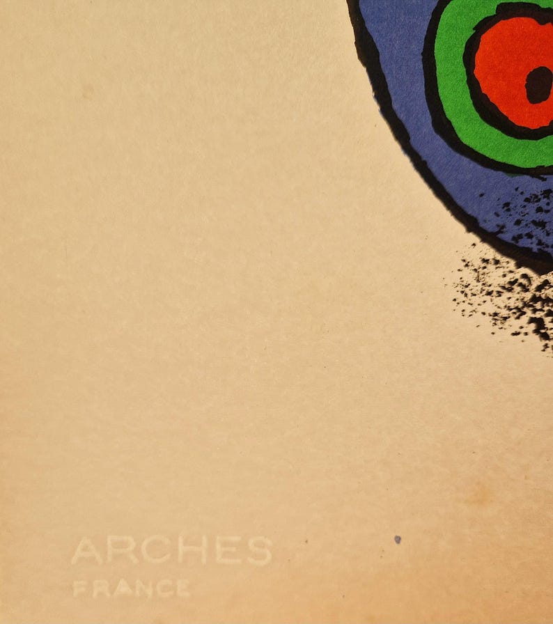 May include: Abstract art print featuring a blue, green, and red circular design with a black outline. The print is on a beige background, with the text "ARCHES FRANCE" in the lower left corner.