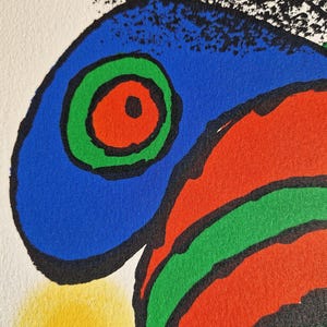 May include: Abstract art print featuring bold colors and shapes. The artwork showcases a blue shape with a green and red circular design, outlined in black. A yellow shape is visible at the bottom left, with white and black shapes at the top.