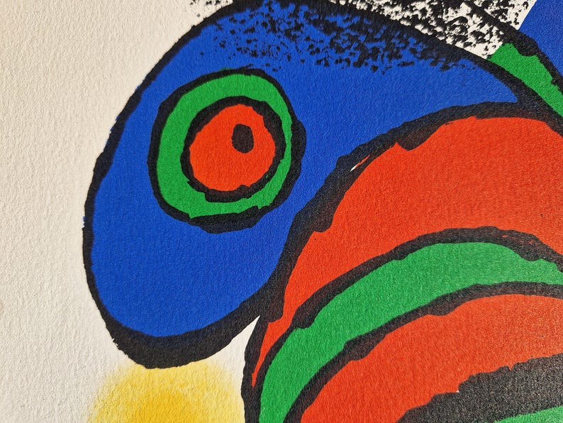 May include: Abstract art print featuring bold colors and shapes. The artwork showcases a blue shape with a green and red circular design, outlined in black. A yellow shape is visible at the bottom left, with white and black shapes at the top.