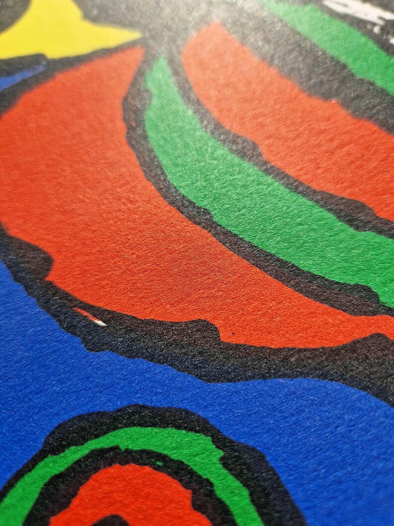 May include: Close-up of a colorful abstract design with bold shapes and colors. The image features a combination of red, green, blue, and yellow hues, outlined in black. The design has a textured appearance.